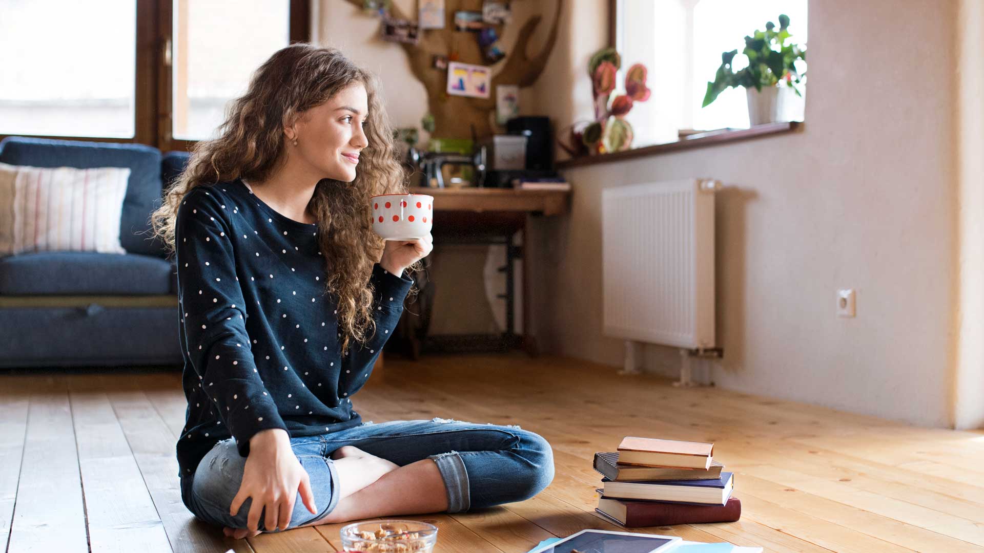 chica tomando café en el living de su casa